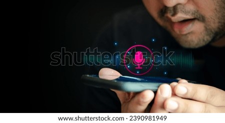 Man using utilizes his smartphone as an AI assistant, effectively using voice commands through its microphone symbol, enhancing productivity with cutting edge technology. Use your voice to direct
