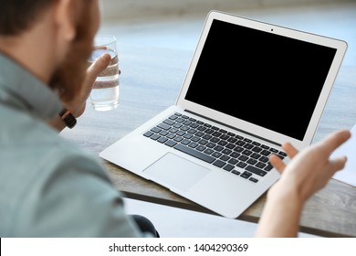 Man using video chat on laptop in home office, closeup. Space for text - Shutterstock ID 1404290369