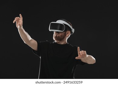 Man using virtual reality headset on black background