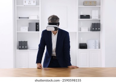Man using virtual reality headset at desk in office - Powered by Shutterstock - Get 15% off with code: PIKWIZARD15