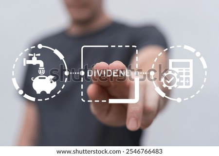 Man using virtual screen clicks word: DIVIDEND. Dividends business, tax, finance and investment concept. A dividend is a payment made by a corporation to its shareholders as a distribution of profits.
