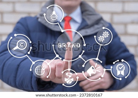 Man using virtual touch screen presses word: BRAND. Concept of brand marketing and management, business branding or rebranding.