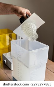 Man using a wash machine to clean a transparent 3d resin object