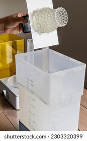 Man using a wash machine to clean a transparent 3d resin object