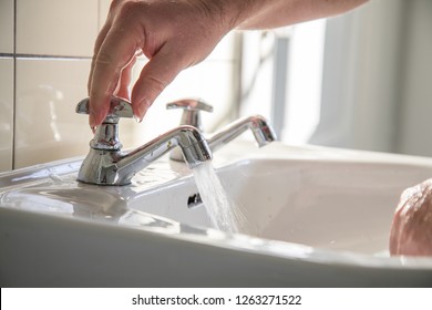 Man using washbasin with tap water for washing hands - Shutterstock ID 1263271522