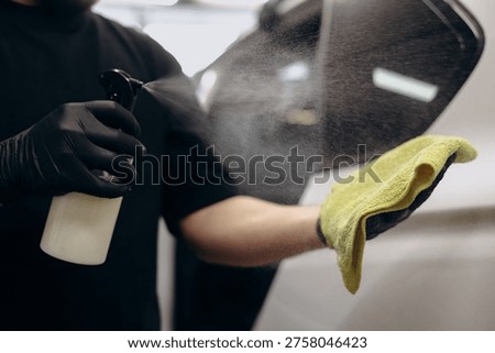 Man using water with soap and micro fiber to clean the car at car detailing service