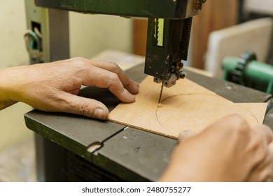 A man is using a woodworking machine to cut a piece of wood. Concept of craftsmanship and precision, as the man carefully operates the machine to create a precise cut - Powered by Shutterstock