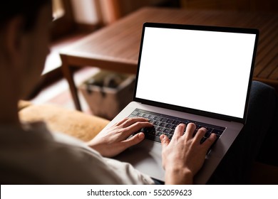 Man Using, Working On Laptop With Blank Screen While Sitting On Sofa In Living Room. Mockup Template