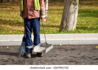 A Man, A Utility Worker, Removes Leaves From The Road With A Special Device.