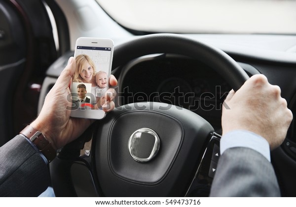 Man video conferencing on smartphone in car. \
Modern technology concept. 