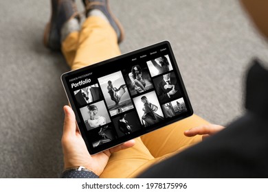 Man Viewing Black And White Fashion Photography Portfolio Website On Tablet Computer