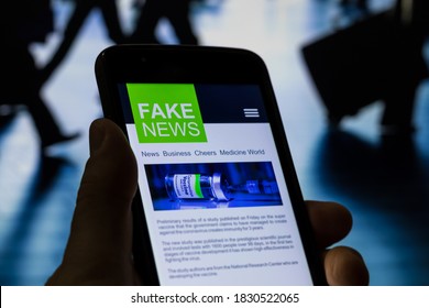 Man Viewing A Fake News Website On The Coronavirus Vaccine With People On The Move At The Busy Airport In The Background