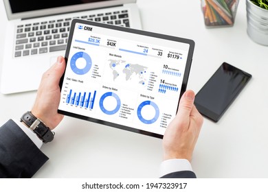 Man viewing infographics on the tablet computer indicating different business data