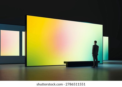 A man viewing a large gradient screen in a modern gallery interior, minimal style on dark background, concept of digital art presentation