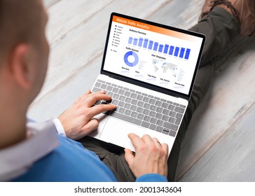 Man viewing website traffic analytics data on laptop computer