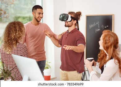 Man With Virtual Reality Glasses Testing New Product During Team Meeting In The Office