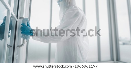 Man in virus protective suite and mask cleaning covid19 infected area, Virus disinfection concept