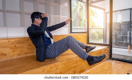 A Man In A VR Headset Is Watching A 3D Movie, Taking A Bright Virtual Tour Shown In A Virtual Reality Glasses Screen. In The Office By The Glass Window