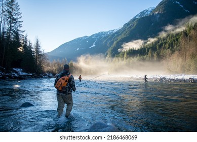 A man in wader walking through the river to get to a fly fishing spot - Powered by Shutterstock