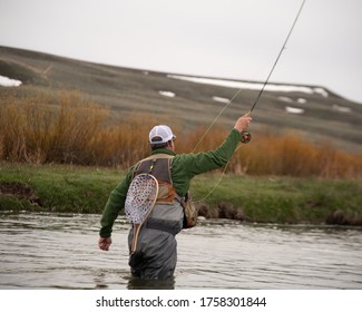 A Man Wading In A River Fly Fishing.