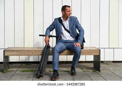 Man Waiting With E-scooter At Busstop