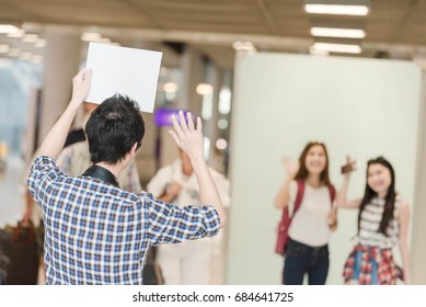 A Man Waiting His Friend In Front Of The Gate And Greeting Her In The Airport.