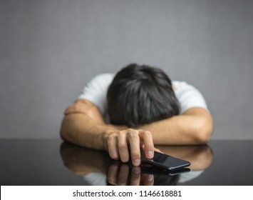 Man waiting for a phone call on table, face down