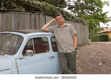 Man Is Waiting For Someone In Front Of A Small  Vintage Car