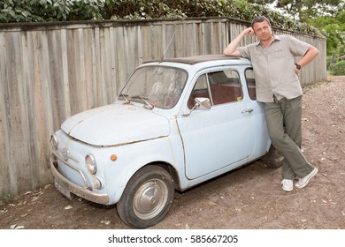 Man Is Waiting For Someone In Front Of A Small Vintage Car