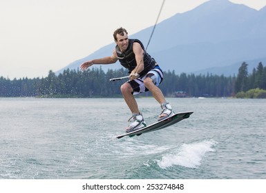 Man wakeboarding on a beautiful mountain lake - Powered by Shutterstock