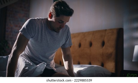 Man Wakes Up, Turns off Alarm Clock with Frustration, after Sleepless Insomniac Night. Early Rising Stressed Man Ready to Face Day of Problem Solving. He is Tired, Upset