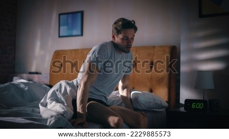 Man Wakes Up, Turns off Alarm Clock with Frustration, after Sleepless Insomniac Night. Stressed Man Ready to Face Day of Problem Solving. Clock Showing Six A.M. Bedroom Nightstand Bedroom
