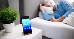 Un Homme Se Réveille Avec Une Alarme Sur Son Téléphone Portable À La Maison