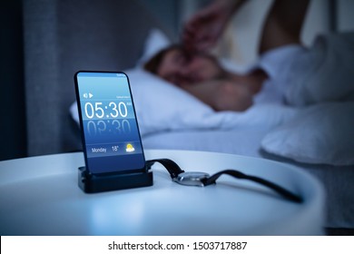 Man Waking Up With Alarm On Mobile Phone At Home - Powered by Shutterstock