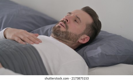 Man Waking Up From Nightmare In Bed