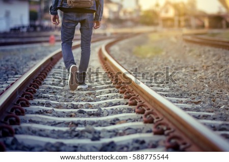 Man walk away on railroad with warm light.Selective focus.Traveler man on railroad.