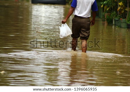 A man walk in high waters. Heavy rains caused floods in Bekasi, West Java/ Indonesia