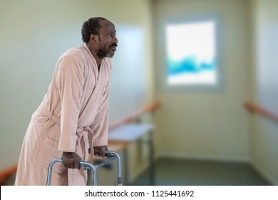 man with walker standing in hospital corridor
