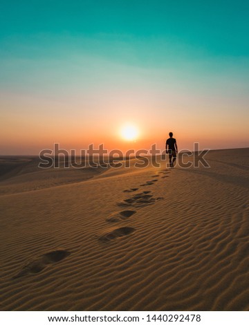 Man walking alone in the dunes of the desert