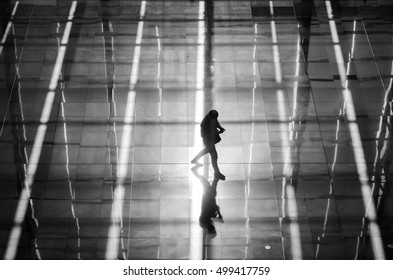Man walking alone with light pattern behind him (black and white)
