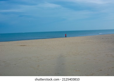 A Man Walking Alone On The Beach. Minimal View.