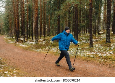 
A man is walking along the road with walking sticks in the forest (Nordic walking) - Shutterstock ID 1058098214