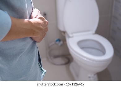 Man Walking To The Bathroom Standing And Touching The Belly In The Toilet He Wants To Pee. Enlarged Prostate Problems In Older Men Causing Urinary Incontinence