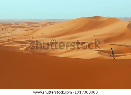 Man walking in desert on duna edge