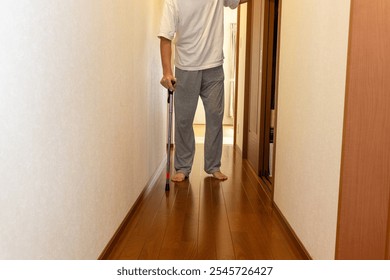 A man walking down a corridor with a cane