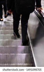Man walking down escalator seen from behind