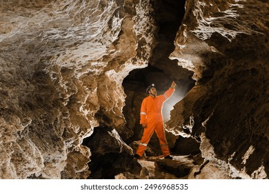 Man walking and exploring dark cave with light headlamp underground. - Powered by Shutterstock