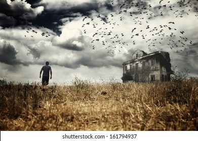 Man Walking In A Field Towards A Haunted House