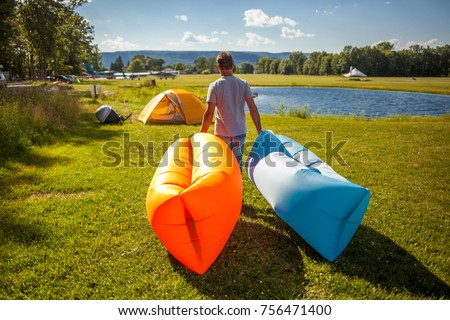 Man walking with Inflatable sofas out in the wild camping
