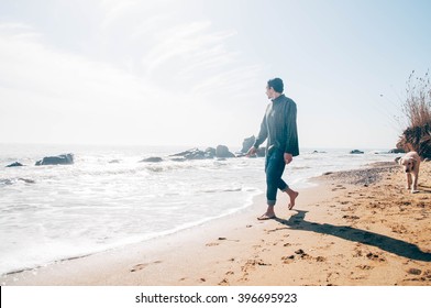 Man Walking With Labrador Dog On Beach